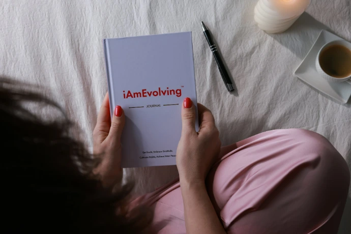Woman reading a journal with a pen and coffee